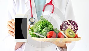 Online diet consultant, Doctor holding smart phone, fresh fruit.