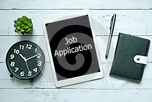 Online digital technology job application concept.Top view of clock,plant,notebook,pen and tablet written with Job Application on