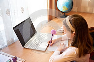 Online education of children. Girl schoolgirl teaches a lesson online using a laptop video chat call conference with a