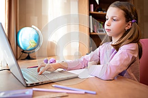 Online education of children. Girl schoolgirl teaches a lesson online using a laptop video chat call conference with a