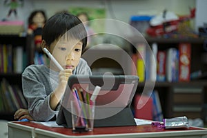 Online education concept. Online class. Asian little boy studying at home. kid in living room at home and using digital tablet to