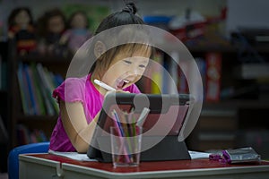 Online education concept. Online class. Asian little girl studying at home. kid in living room at home and using digital tablet to