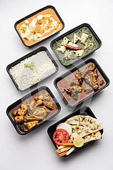 Online food delivery concept for Indian Restaurant showing plastic containers with food