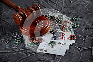 Online gambling and justice theme, cards, playing chips and judge gavel on old grey table