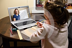 Online home education, tutor teaches preschool child during quarantine due to coronavirus. Kid learning with teacher by laptop photo