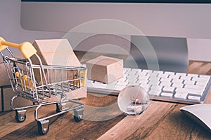 Online internet global purchases transportation business, cardboard boxes, trolley, earth globe on table with keyboard, mouse and