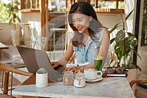 Online Job. Girl With Laptop At Cafe. Business Woman In Jeans Outfit Working At Coffee Shop. Digital Nomad Lifestyle photo