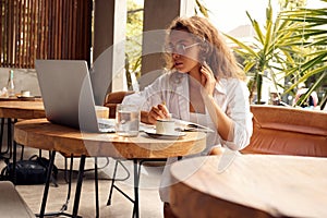 Online Job. Serious Girl Working With Laptop At Cafe