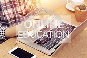 Online learning course concept. student using computer laptop for training online and writing lecture note in notebook