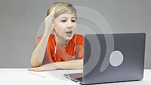 On online learning in front of a laptop, the boy very emotionally pulls his hand to the teacher asking him