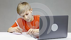 On online learning in front of a laptop, the boy very emotionally pulls his hand to the teacher asking him