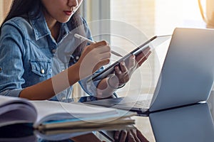 Online learning, home school concept.Young asian woman using digital tablet, work on laptop computer