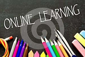 Online learning in Quarantine inscription on the background of a blackboard and school supplies .Homeschooling during quarantine.