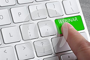 Online learning. Woman pressing button on computer keyboard with word Webinar, closeup