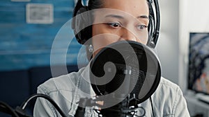 Online live radio talk show host filming remote podcast while talking to public at home studio desk