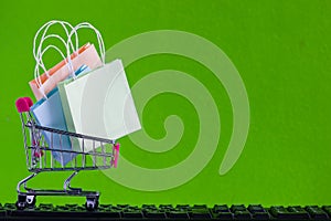 Online market place, eCommerce concept : Shopping cart with shopping bag ready to shop on black keyboard Ordered by customer