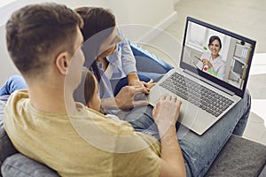 Online medical consultation for family patients. Doctor woman video call using laptop talks with family sitting on the