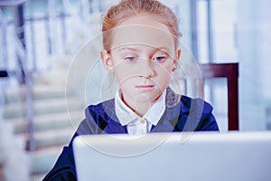 Online meetings and web conferencing. Humorous image of young cute child business girl conferencing with colleague on laptop.