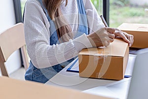 Online merchants are writing customer shipping information on the front of the parcel box.