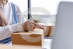 Online merchants are writing customer shipping information on the front of the parcel box.