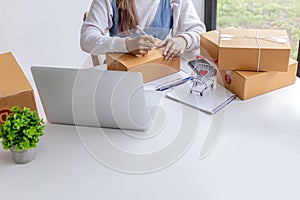 Online merchants are writing customer shipping information on the front of the parcel box.