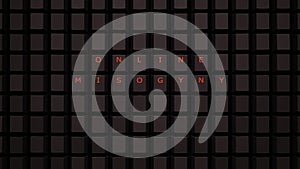 Online Misogyny Concept Illuminated Orange Keys on a Black Keyboard Grid Wall Spelling the Word Misogyny photo