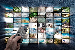 Online Multimedia video concept on TV set in dark room. Man watching online TV with remote control in hand. Multimedia streaming