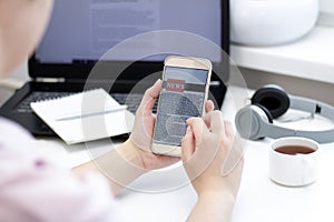 Online news on a mobile phone. Close up of businesswoman reading news or articles in a smartphone screen application.