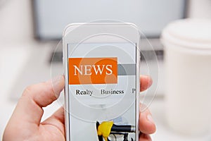 Online news in mobile phone. Close up of smartphone screen. Man reading articles in application. Hand holding smart