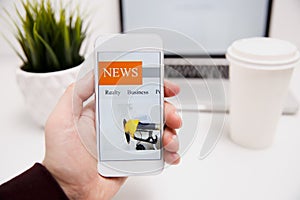 Online news in mobile phone. Close up of smartphone screen. Man reading articles in application. Hand holding smart