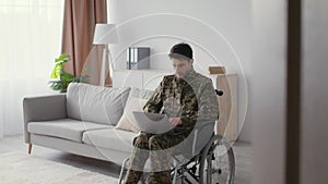 Online opportunities for veterans. Young man soldier with disability typing on laptop, working in internet at home