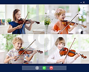 Online orchestra rehearsal. Kids play violin photo