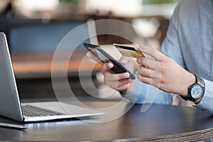 Online payment, Close up man& x27;s hands holding smartphone and using credit card for online shopping