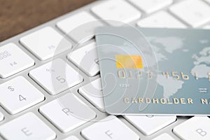 Online payment concept. Bank card on computer keyboard, closeup