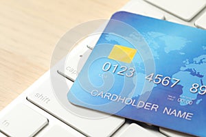 Online payment concept. Bank card and computer keyboard on table, closeup