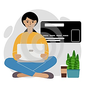 Online payment concept. Close up of a large credit card. A woman sits cross-legged, holding a laptop in his hand.