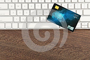 Online payment. Credit card and keyboard on wooden table, top view with space for text