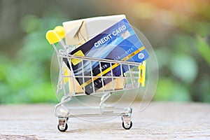 Online payment credit card and parcel boxes in shopping cart - shopping online technology and credit card payment concept