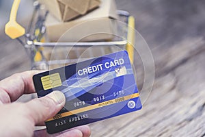 Online payment credit card and parcel boxes in shopping cart - shopping online technology and credit card payment concept