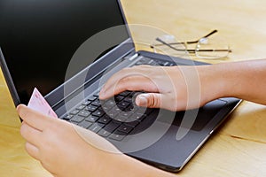Online payment hand holding a credit card and working on laptop on of Cyber Monday