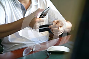 Online payment : Man holding a smart phone and credit card ready to make a purchase