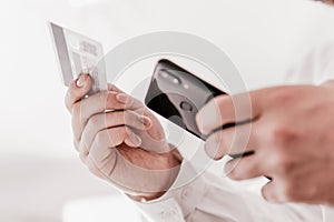 Online payment, Payment online shopping smartphone at working place. Man`s hands holding a credit card Man hand credit card