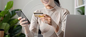 Online payment, Woman hands holding a credit card and using smartphone for online shopping at home