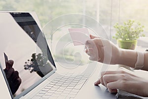 Online payment,woman`s hands holding smartphone and using credit card for online shopping