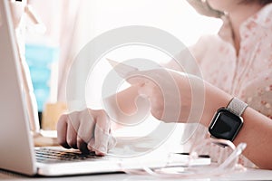 Online payment,woman`s hands holding smartphone and using credit card for online shopping