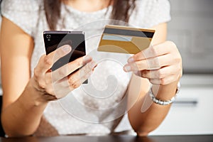 Online payment, women`s hands holding a credit card and using smart phone for online shopping