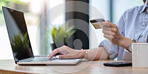 Online payment,Young woman`s hands using computer and hand holding credit card for online shopping