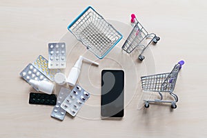 Online pharmacy concept. Buying medicine online over the phone. Delivery of pharmaceuticals. Mini trolley with different