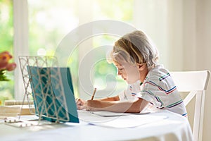 Online remote learning. School kid doing homework
