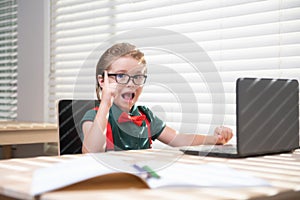 Online remote learning. School kids with computer having video conference chat with teacher in class. Child studying at